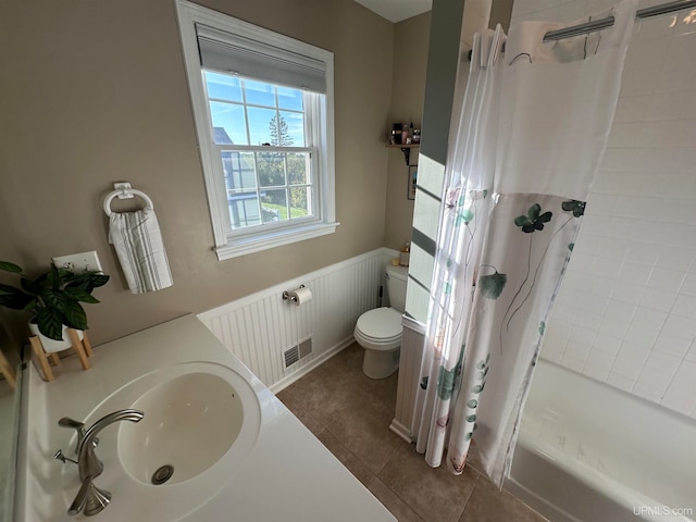 full bathroom with toilet, shower / bath combo with shower curtain, sink, and tile patterned floors