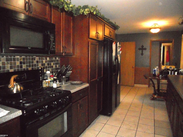 kitchen featuring decorative backsplash, black appliances, and light tile patterned floors