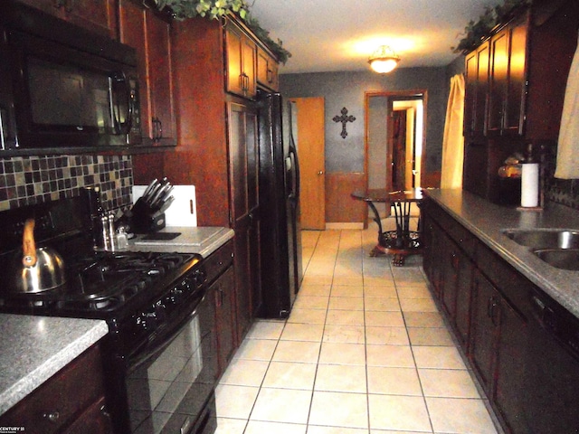 kitchen with black appliances, sink, light tile patterned floors, and tasteful backsplash