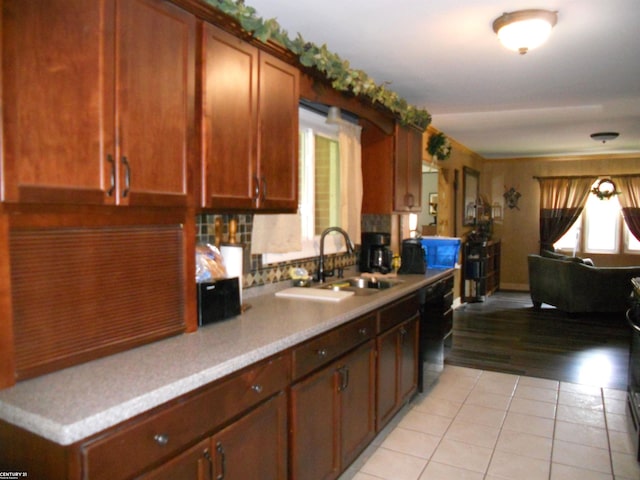 kitchen featuring light hardwood / wood-style flooring, black dishwasher, and sink