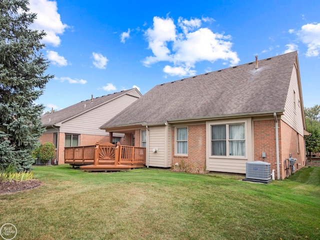 rear view of house with a wooden deck, a yard, and central AC unit