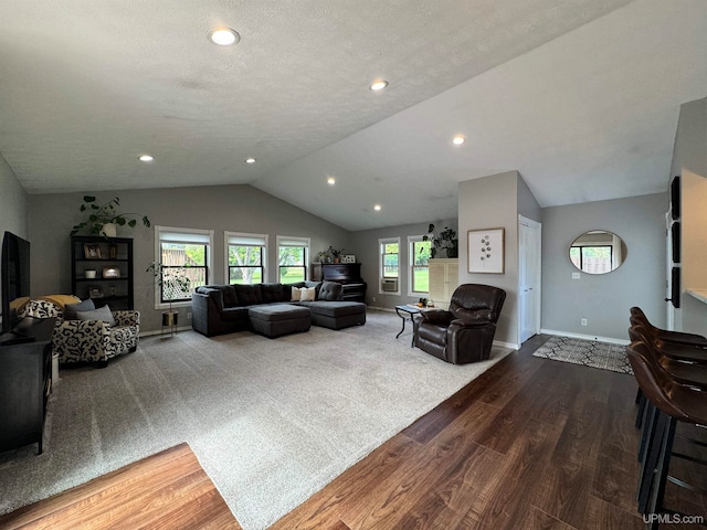 living room with a textured ceiling, vaulted ceiling, and hardwood / wood-style flooring