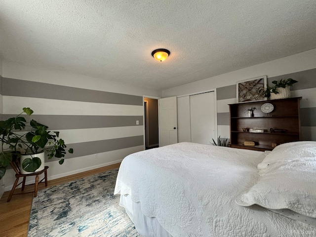 bedroom featuring hardwood / wood-style flooring and a textured ceiling