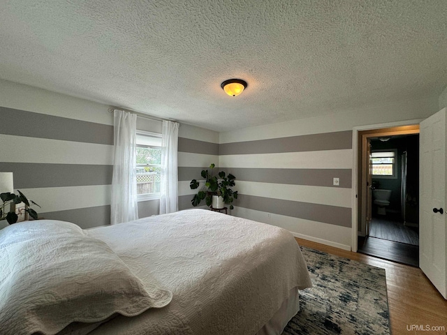 bedroom with a textured ceiling and hardwood / wood-style flooring