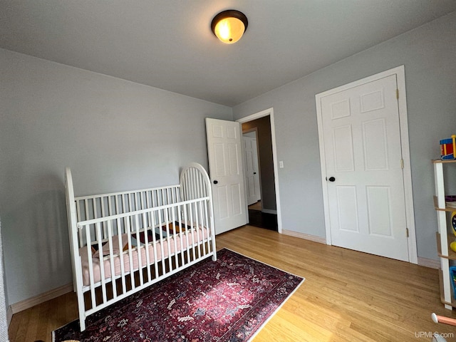 bedroom featuring a crib and hardwood / wood-style floors