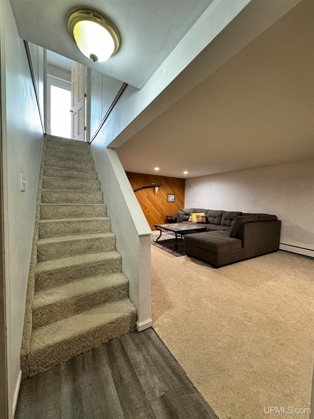 stairway with wooden walls and carpet floors