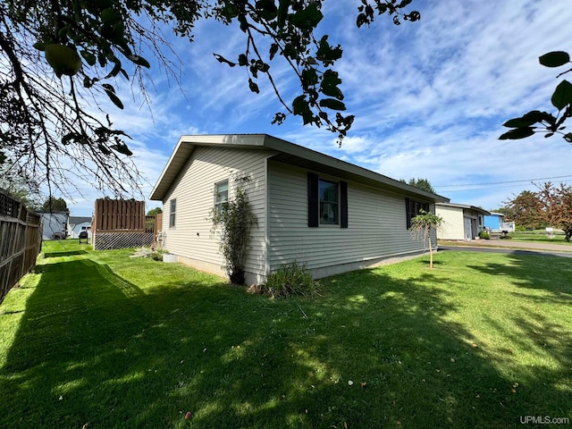 view of side of home with a yard