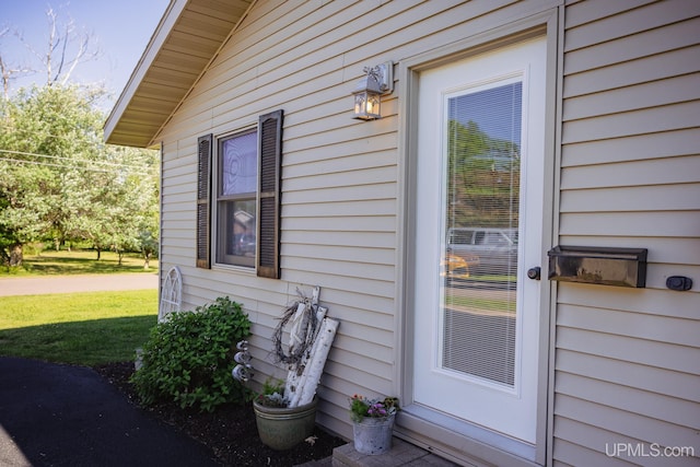 view of exterior entry with a lawn