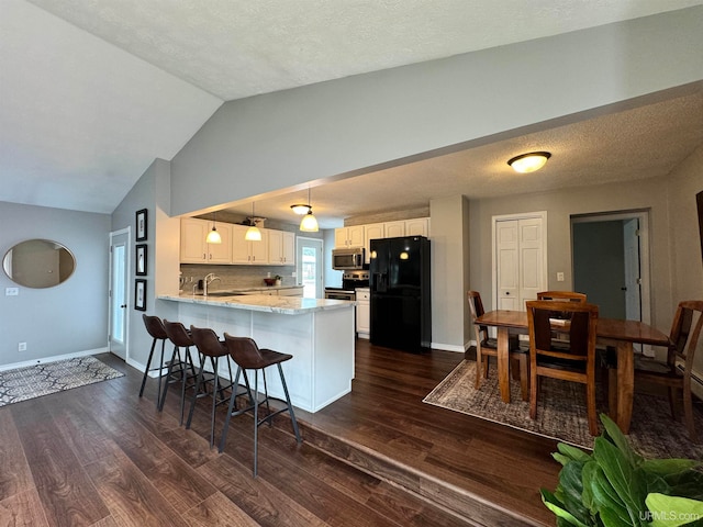 kitchen with white cabinets, kitchen peninsula, pendant lighting, black refrigerator with ice dispenser, and dark hardwood / wood-style floors