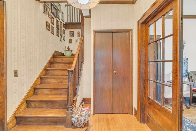 stairway featuring wood-type flooring and ornamental molding