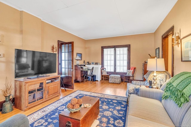 living room with crown molding and hardwood / wood-style floors