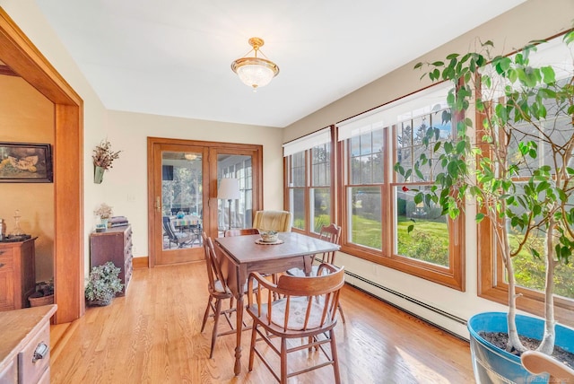 dining space featuring a baseboard heating unit and light hardwood / wood-style floors