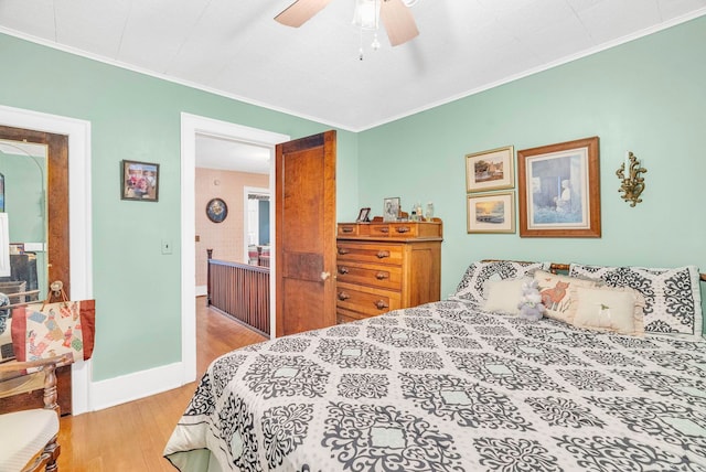 bedroom with light wood-type flooring, crown molding, and ceiling fan