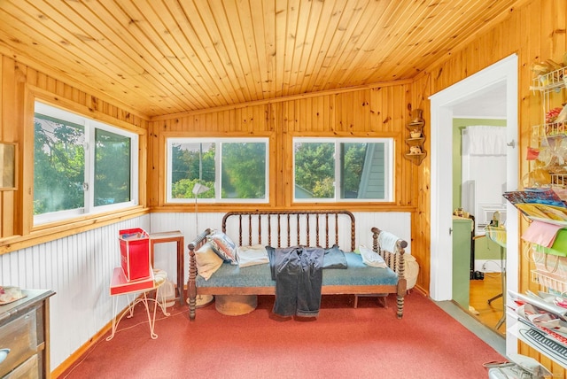 interior space featuring carpet flooring, wooden walls, wood ceiling, and vaulted ceiling