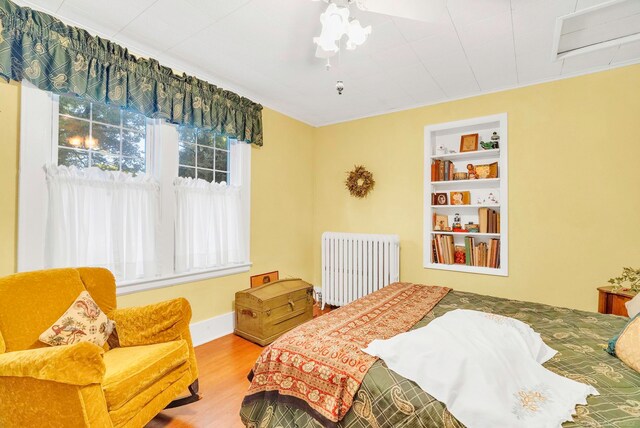 bedroom featuring radiator and hardwood / wood-style floors