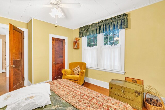 bedroom with ceiling fan, ornamental molding, and hardwood / wood-style floors