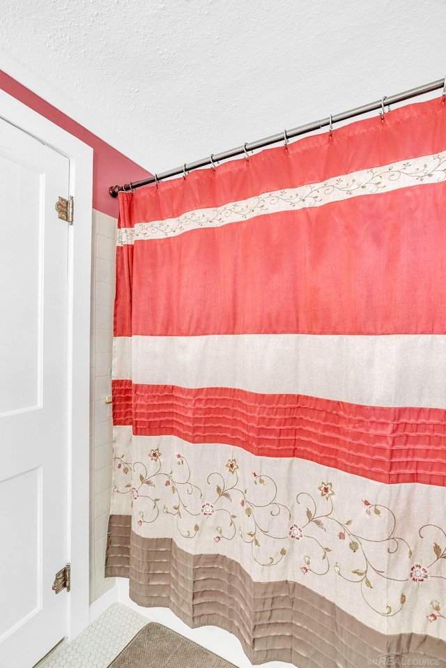 bathroom with a textured ceiling and walk in shower