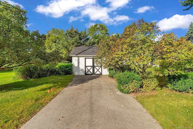 view of front of property featuring a shed and a front lawn