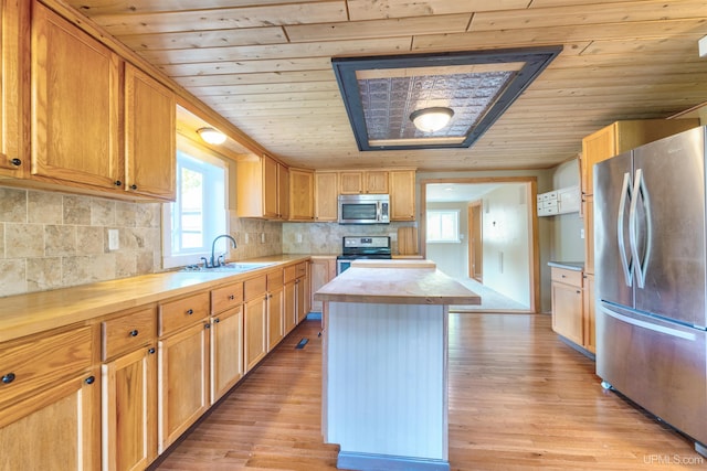 kitchen with light hardwood / wood-style floors, sink, a kitchen island, stainless steel appliances, and wooden ceiling