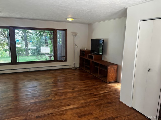 unfurnished living room featuring a textured ceiling, dark hardwood / wood-style flooring, and a baseboard heating unit