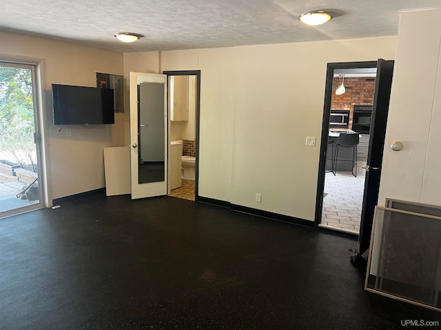 empty room with a textured ceiling and electric panel