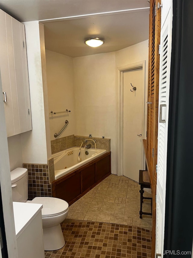 bathroom featuring tile patterned flooring, a bathing tub, toilet, and vanity