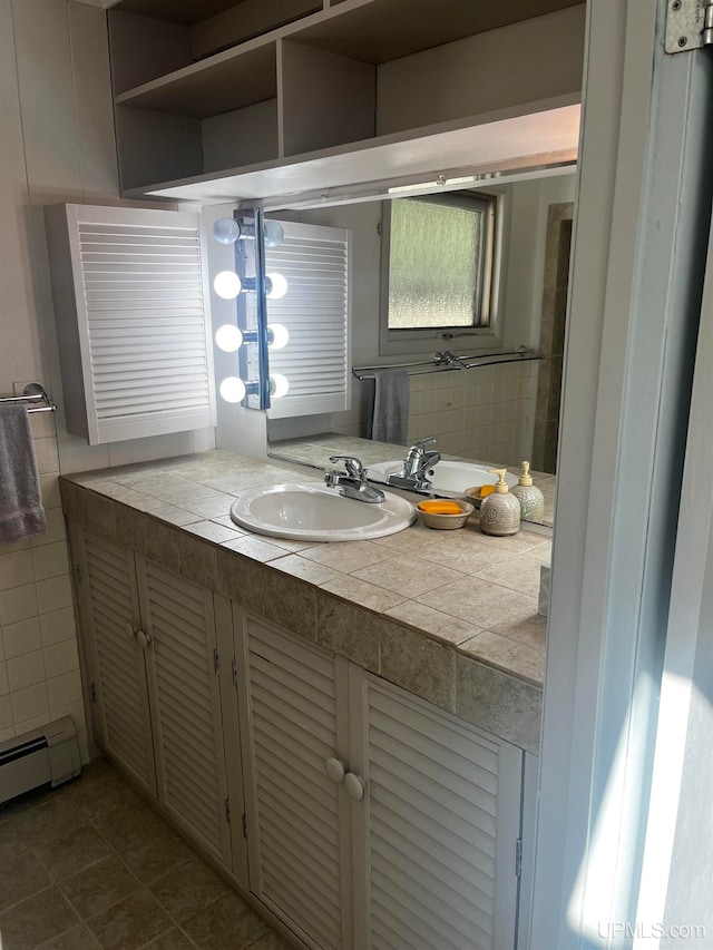 bathroom featuring a baseboard heating unit, tile patterned flooring, and vanity