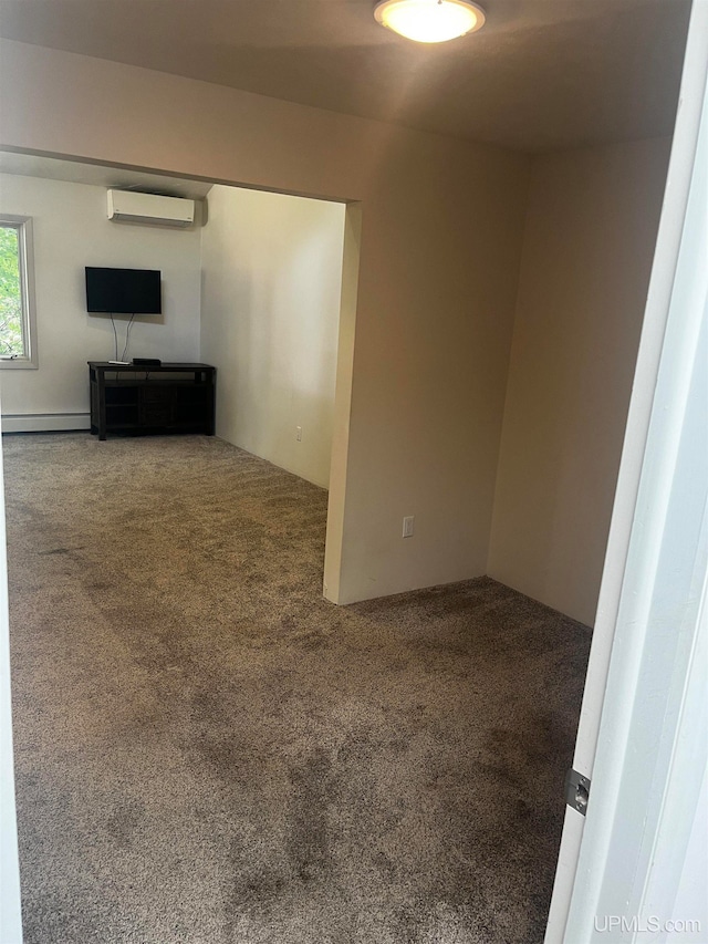 carpeted spare room with a baseboard radiator and a wall mounted air conditioner