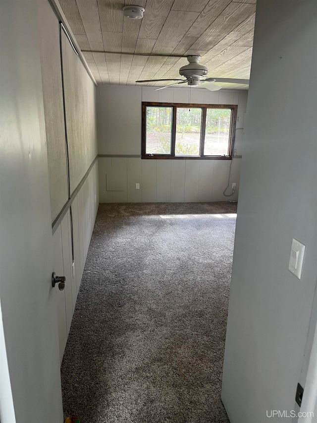 carpeted spare room with ceiling fan and wooden ceiling