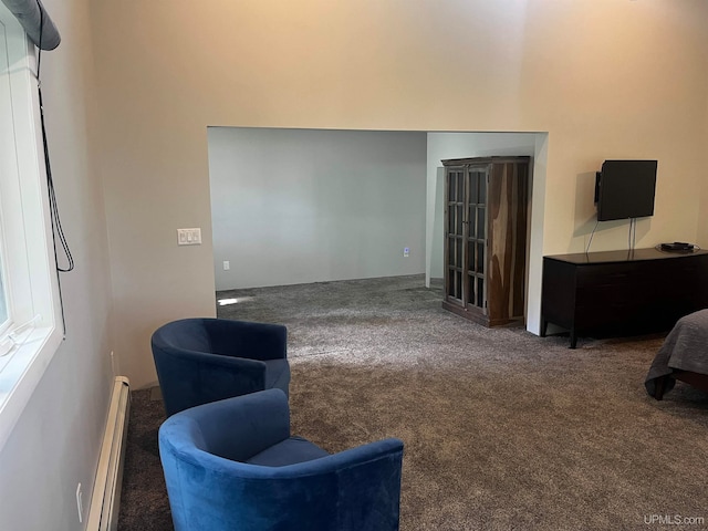 sitting room featuring dark carpet and baseboard heating