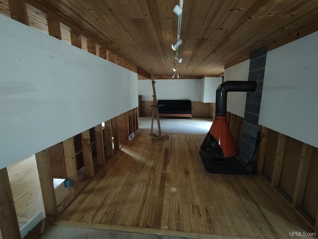 interior space featuring rail lighting, light hardwood / wood-style floors, wooden walls, and wood ceiling