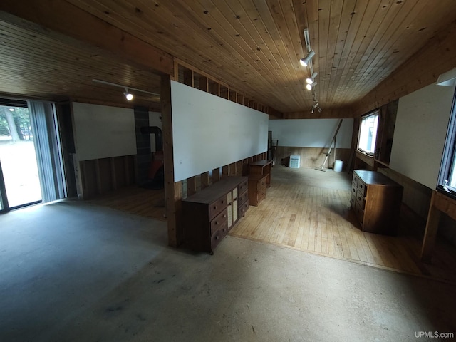 basement with wooden walls, wood ceiling, light hardwood / wood-style floors, and a healthy amount of sunlight