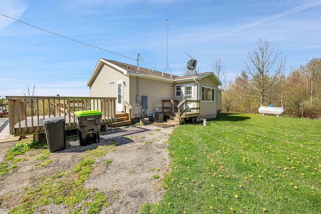 back of house with a wooden deck, a yard, and central air condition unit