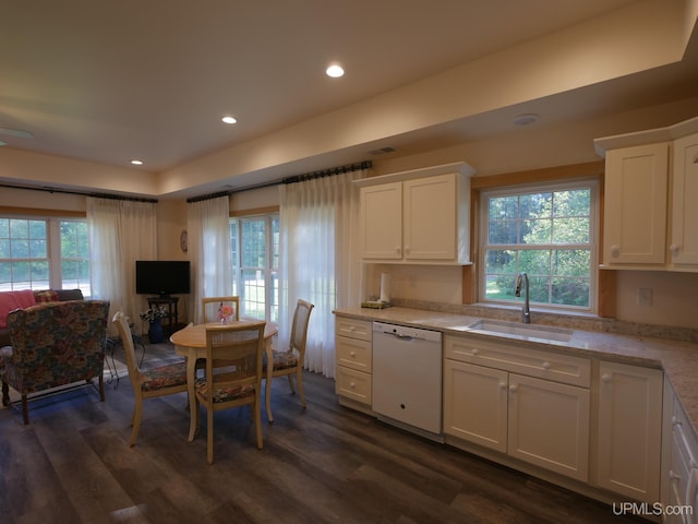 kitchen with white cabinets, white dishwasher, dark wood-type flooring, and sink