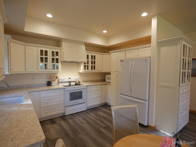 kitchen featuring white appliances, dark hardwood / wood-style floors, white cabinetry, and premium range hood