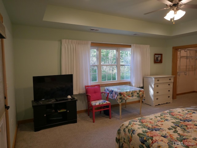 bedroom with visible vents, baseboards, a tray ceiling, and carpet