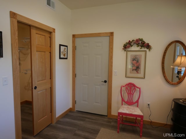 foyer entrance with visible vents, baseboards, and wood finished floors