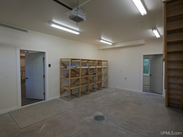 garage featuring a garage door opener and baseboards