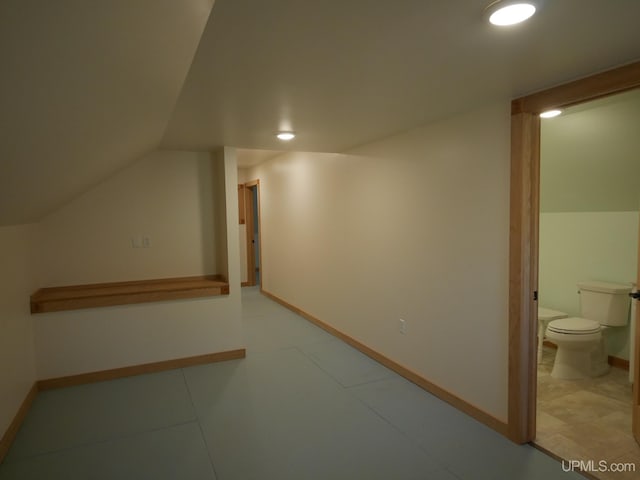 bonus room with vaulted ceiling and tile patterned floors