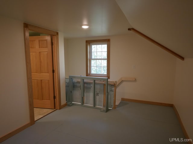 additional living space featuring baseboards and lofted ceiling
