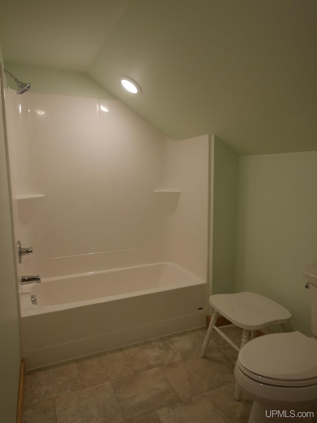 bathroom featuring lofted ceiling, bathing tub / shower combination, and toilet