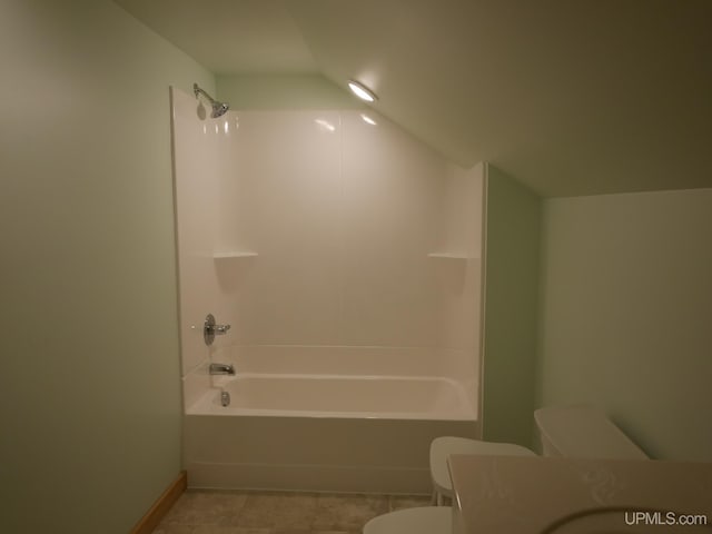 full bathroom featuring tub / shower combination, lofted ceiling, vanity, and toilet