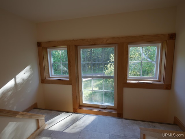 doorway to outside featuring light tile patterned floors and a healthy amount of sunlight