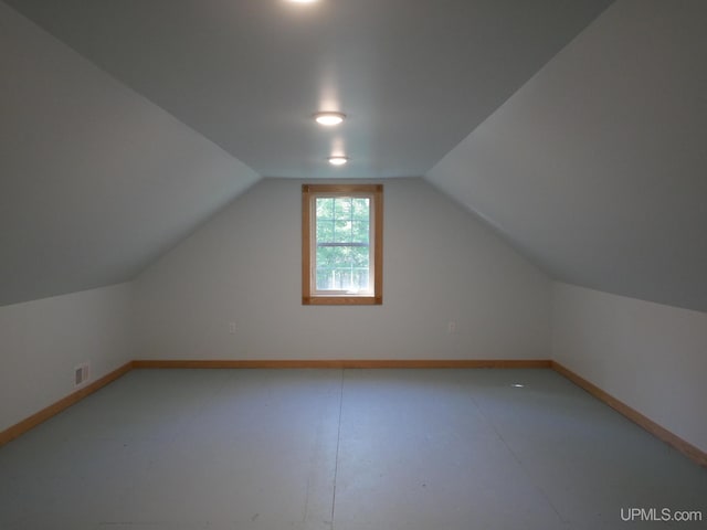 additional living space with visible vents, baseboards, and lofted ceiling