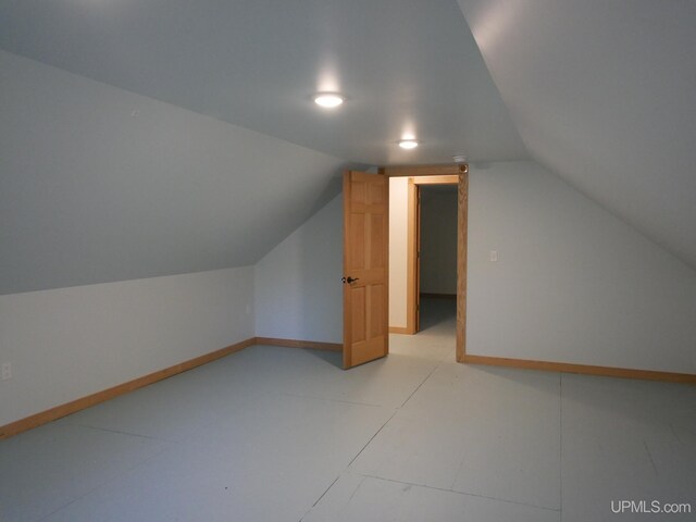 additional living space featuring baseboards and lofted ceiling