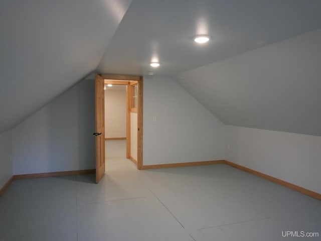 additional living space featuring baseboards and vaulted ceiling