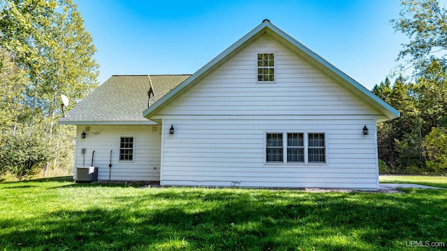 rear view of property with a yard and central AC unit