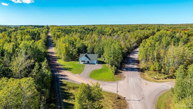 bird's eye view with a wooded view