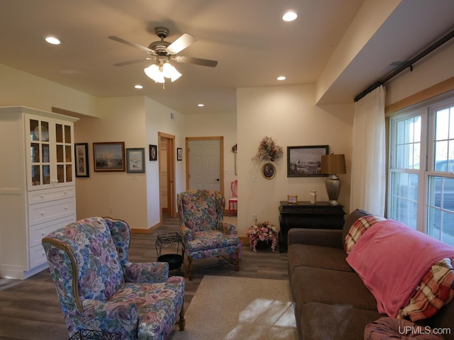 living room with ceiling fan and dark wood-type flooring