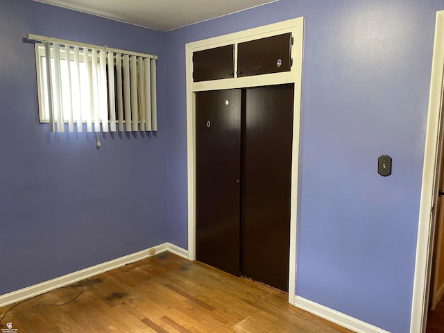 unfurnished bedroom with a closet and hardwood / wood-style flooring